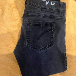 Dondup George mörkgrå 34 - Snygga svarta jeansbyxor med en klassisk femficksdesign. De har en knapp och dragkedja framtill. Perfekta för en stilren look.