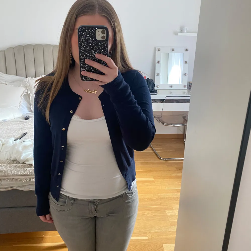 Säljer en stilren mörkblå kofta från Holly & White. Koftan har långa ärmar och knappar framtill. Passar till många olika outfits.. Neuletakit & Villapaidat.