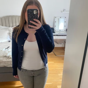 Mörkblå kofta från Holly & White - Säljer en stilren mörkblå kofta från Holly & White. Koftan har långa ärmar och knappar framtill. Passar till många olika outfits.