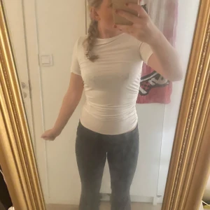 Vit tight t-shirt - Säljer en vit tight t-shirt med korta ärmar. Perfekt för en enkel och stilren look. Passar bra till både jeans och kjol. Knappt använd 
