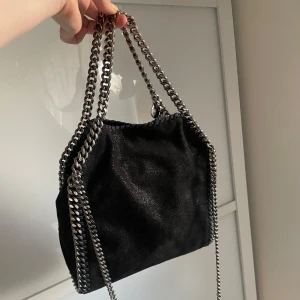 Stella McCartney mini tote fallabella - Säljer nu min favoritväska då jag behöver pengarna💔 Nypris runt 9000. Väskan är i bra men använt skick. Kedjan har börjat tappat lite färg där man håller den men det är inget som synns tydligt när man använder den. Köpte från Stella McCartneys hemsida och har kvar dustbag och orginalboxen, allt kommer med. Skriv privat vid frågor.