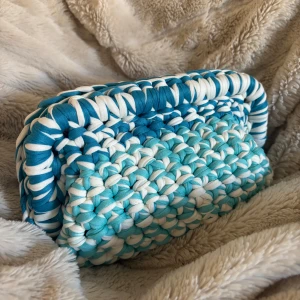 Vit/blå handvirkad nessecär  - Säljer en vit/blå handvirkad nessecär som jag har virkat!. Den är i ett mjukt garn och är väldigt rymlig! Kan även bäras i handen som en clutch.  Kan Även Göra Andra Färger / storlekar💕 skriv för mått, olika på vissa 💕