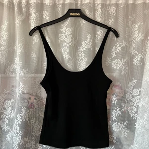 Svart ribbad linnetopp från H&M - Svart ribbat linne från H&M, säljer då jag ej använder det men det finns inga fel på den! :) Storleken är S men skulle säga att den säkert även passar M! OBS, katt finns i hemmet.