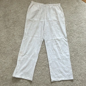 Vita linnebyxor från Gina Tricot - Säljer ett par vita linnebyxor från Gina Tricot i storlek M. Byxorna har en avslappnad passform med elastisk midja och knytband för extra komfort. Perfekta för varma dagar! Dem har lite fläckar här och var men som är väldigt diskreta
