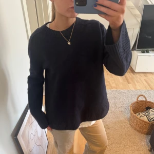 100% cashmere kashmirtröja från COS - Säljer en stilren mörkblå stickad tröja från cos  rund halsringning och långa ärmar. Perfekt för kyligare dagar och enkel att matcha med olika outfits. Tröjan har en klassisk design med ribbade muddar vid ärmslut och nederkant. 100% Kashmir 
