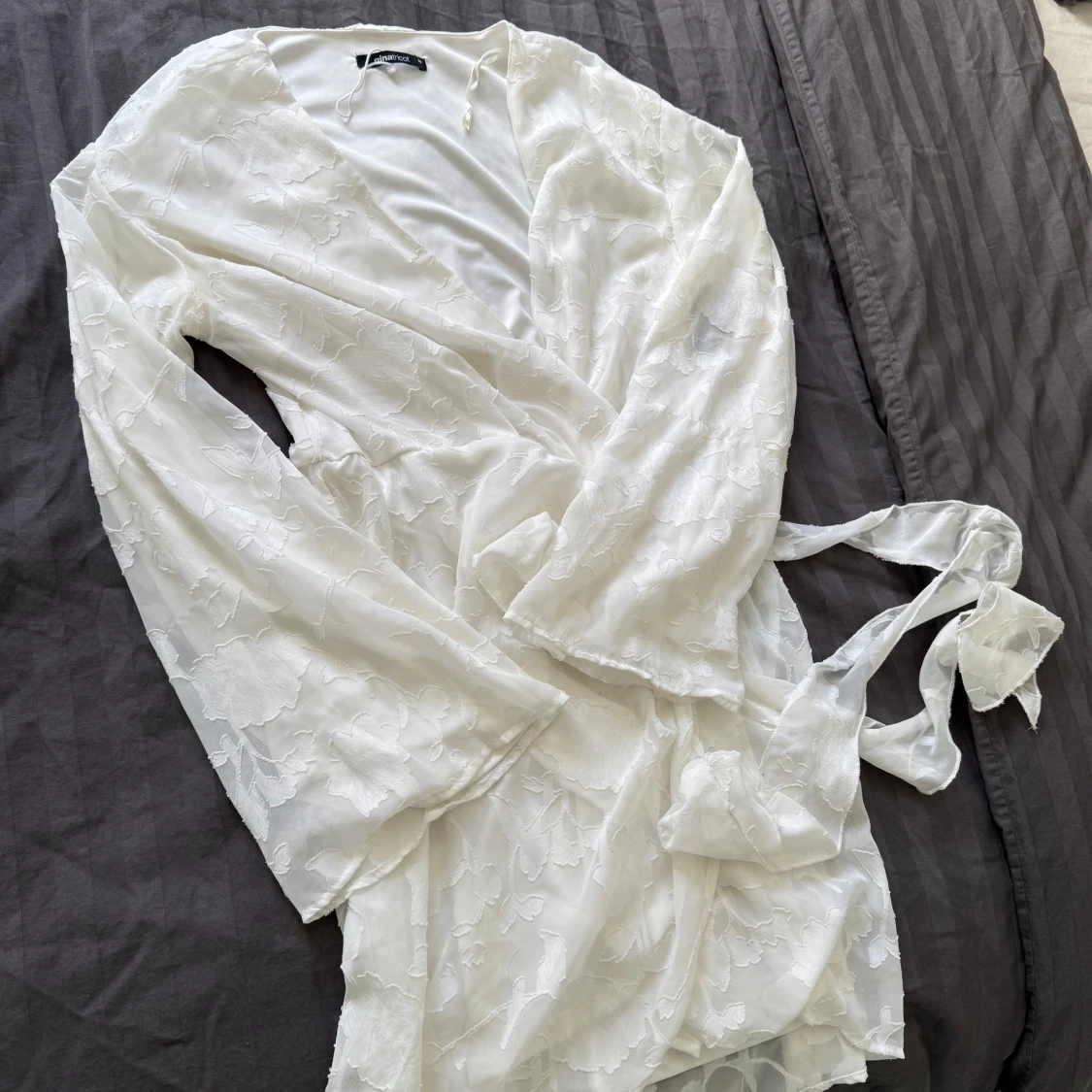 Vit omlottklänning med blommigt mönster