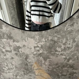 Vit och svart randig croppad tröja - Säljer en snygg vit och svart randig croppad tröja med långa ärmar. Perfekt för en trendig look. Passar bra till jeans eller kjol för en avslappnad stil.
