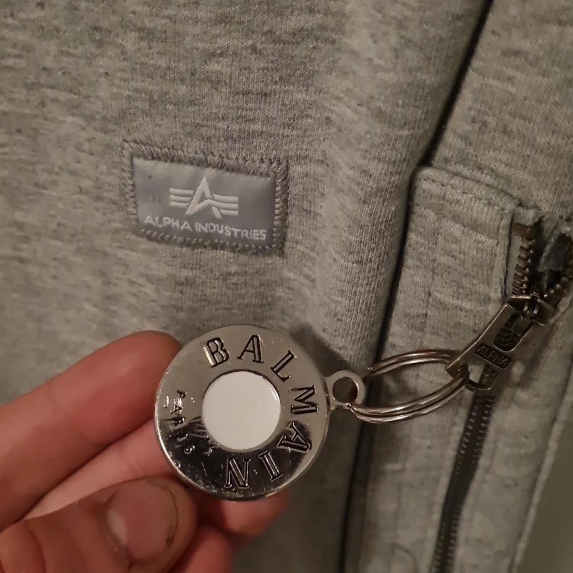 Grå sweatshirt från Alpha Industries har balmain på armen - 3