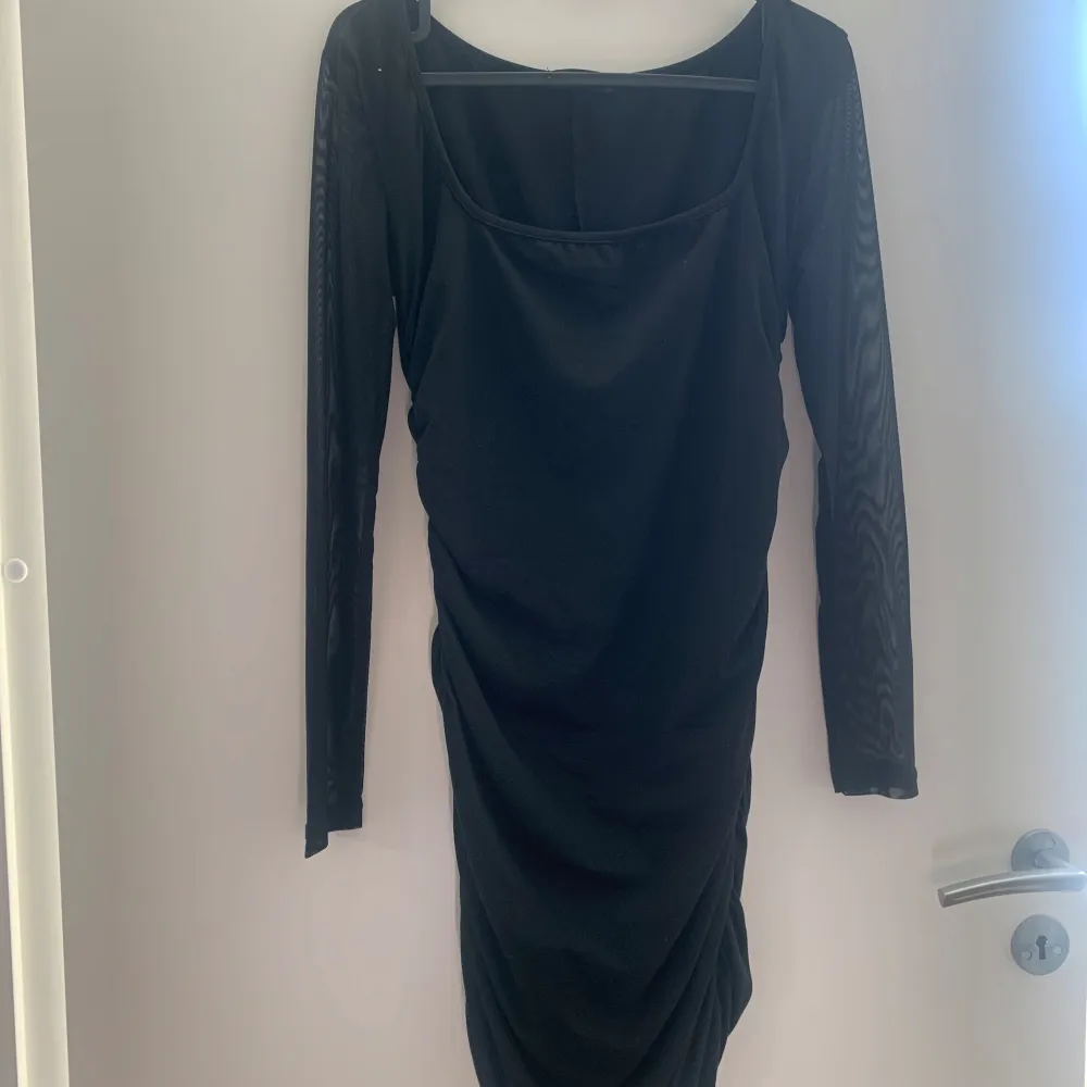 Snygg svart klänning från Shein med långa ärmar och rynkdetaljer. Perfekt för en stilren look. Klänningen har en åtsittande passform och är tillverkad i ett mjukt material.. Mekot.