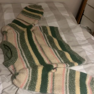Randig stickad tröja från Vero Moda - Säljer en mysig stickad tröja från Vero Moda i storlek S. Tröjan har ett randigt mönster i grönt, beige och rosa. Perfekt för kyliga dagar med sin långärmade design och mjuka material. Alldrig andvänd!