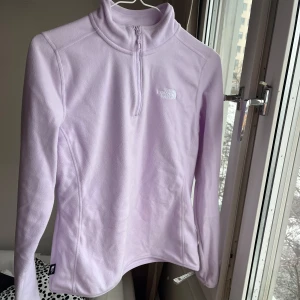 Ljuslila fleece från The North Face - Säljer en mysig ljuslila fleece från The North Face med halv dragkedja och broderad logga på bröstet. Nypris 750:-💜