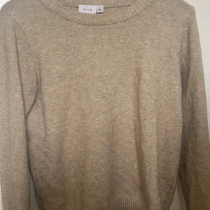 Beige stickad tröja från Vila - Säljer en stilren beige stickad tröja från Vila. Köptes för 1 år sen. Jättebra skick, den är skön, stilren och passar perfekt till både vardag och chill. För ett tag sedan gick en söm vid ärmen upp, men den är snyggt och ordentligt lagad, så det syns knappt. Annars är tröjan i toppskick.