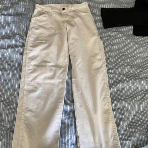 Vita carpenter byxor från Dickies - Säljer ett par vita byxor från Dickies med raka ben och klassisk femficksdesign. Byxorna har normal passform och är tillverkade i bomull. Perfekta för en clean och stilren look.