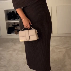 Nakd offshoulder långklänning - Mörkbrun ribbad off shoulder klänning från nakd. Strl XS och den är insydd men ganska stor i strl. Passar xs-L 