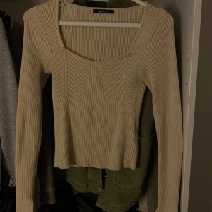 Beige ribbad långärmad topp från Gina Tricot - Säljer en beige långärmad topp från Gina Tricot. Toppen är ribbad med en snygg fyrkantig ringning. 