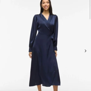 Mörkblå omlottklänning - En fin satinklänning från Vila, storlek 40. Endast använd en gång och i mycket fint skick! Hör av er om ni har några frågor🥰