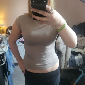 Två bas t-shirts i beige och svart - Säljer två enkla och stilrena t-shirts i beige och svart. Båda har rund halsringning och korta ärmar, med en tight passform. Perfekta att matcha med jeans eller kjol för en clean look. Använda en gång💕 För en av de kostar det 40kr men för båda kostar det 80kr!💕