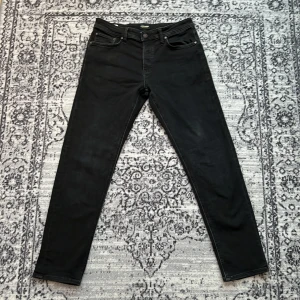Svarta jeans från Jack & Jones - Säljer ett par svarta jeans från Jack & Jones. Jag har använt jeansen, dem är i bra sick men det finns syn på användning i fickorna fram på jeansen. 