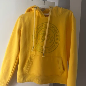 Gul hoodie från La Folie Douce - Säljer nu min skitsnygga hoodie från La Folie Douce med tryck framtill och på ärmen. Så så så snygg, perfekt ute i backen men även nu i sommar en sen sommarkväll💛💛Aldrig använd . Går endast att köpa i deras butiker!!