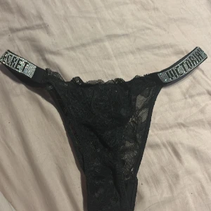 Svarta trosor från Victoria's Secret  - Säljer en svart Trosa från Victoria's Secret i spets med glittrig band storlek S/M använda 1 gång 