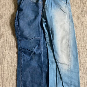 Två par jeansbyxor från Jack & Jones - Säljer två par jeansbyxor från Jack & Jones. Ena paret är mörkblåa och det andra är ljusblåa med en tvättad look. Klassisk femficksmodell med normal passform och raka ben. Perfekta för en avslappnad stil. Workwear jeans står ingen storlek men sitter som m, 300kr för båda 