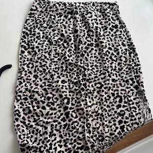 Leopardmönstrad kjol - Säljer en snygg leopardmönstrad kjol i svart och beige. Kjolen har en rak passform och är perfekt för dig som vill sticka ut lite extra. Den är mjuk och skön att ha på sig och passar till många olika stilar. (Midi)