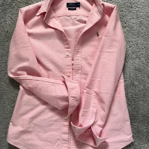  Polo Ralph Lauren Skjorta - Säljer en rosa skjorta från Ralph lauren i extremt bra skick.  Jag säljer den eftersom att jag föredrar en större storlek för mig. På bilden är jag 171 och väger 57 kg. Skriv vid intresse.