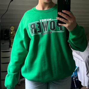 Grön sweatshirt med tryck - Säljer en grön sweatshirt med tryck på bröstet och ett litet på ryggen. Är köpt på en thrift store, och säljs nu för att minska garderoben vid flytt💚 Frakt tillkommer