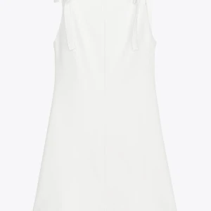 Vit ärmlös klänning med knytband - Superfin vit klänning med knytband på axlarna och rak passform. Klänningen är ärmlös och har en enkel, stilren design som passar perfekt till sommarens alla tillfällen . Materialet känns mjukt och lätt. Aldrig använd.