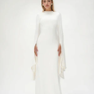 Vit långklänning med pärldetaljer - Elegant vit långklänning med långa, vida ärmar och pärldetaljer längs ärmsluten. Storlek xs ej genomskilnig och väldigt rikt material. 