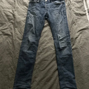 Blå jeans från Jack & Jones - Säljer ett par klassiska blå jeans från Jack & Jones. Byxorna har normal passform, raka ben och fem fickor. Stängs med knapp. Perfekta till vardags och enkla att matcha med olika stilar.