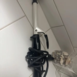 Locktång från Philips - Säljer en svart och silver locktång från Philips med smalt handtag och klämma. Perfekt för att skapa snygga lockar och vågor i håret. Sladden är lång och flexibel för enkel styling. Vet tyvärr inte storleken men blir lite mindre/tajtare lockar🌺
