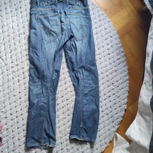 Levi's Engineered jeans - Klassiska blå jeansbyxor från Levi's med raka ben och fem fickor. Byxorna har kontrastsömmar och bälteshällor. 