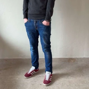 Blå jeansbyxor från Nudie Jeans - Säljer ett par stilrena blåa nudie jeans!😄de är i storlek W27 L32 men jag skulle säga att de passar W28, priset är ej hugget i sten, hör av er om mi har några funderingar💭