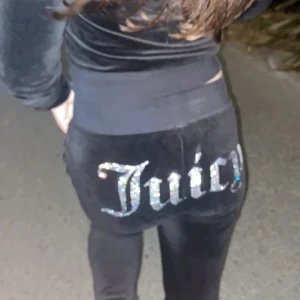 Svarta Juicy Couture byxor - Svarta mjukisbyxor från Juicy Couture med glittrig Juicy-text baktill. Pris går att diskutera, defekt från nagellim (se sista bilden) annars fint skick. Nypris 1200 kr🫶🏻