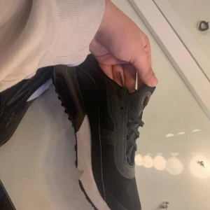 Svarta Nike Air Max sneakers - Säljer ett par svarta Nike Air Max sneakers med vit sula och synlig Air-enhet i hälen. Skorna har snörning och är tillverkade i syntetmaterial och mesh för bra andningsförmåga. Perfekta för en sportig och stilren look. Köptes för ungefär 1400 för 3 år sen har inte använts sen dess 