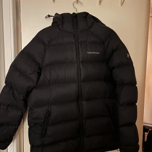 Svart down hood W dunejacka från Peak Performance - Säljer en svart jacka från Peak Performance har använt Max 10gånger inga skador den e i nyskick köpte för 4200kr