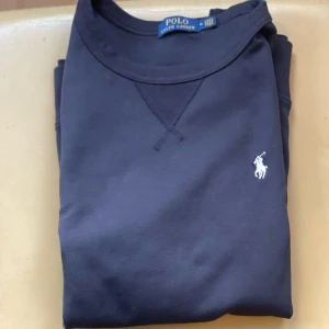 Marinblå Polo Crewneck - Blå Ralph Lauren tröja med vit logga, storlek M. Mycket bra skick, passade inte mig därför säljer jag den.