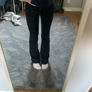 Svarta jeans med bootcut - Svarta låg midjade bootcut jeans. Har en knapp och dragkedja framtill. De har knapp fickor i bak. Dom är från Gina i storlek 158 men passar mig perfekt som är 160 och i vanliga fall har storlek 24 i midja och 30 i längd. Dom går att fixa i midjan då dom är justerbara. Inga defekter mer en att dom saknar en knapp i bak på en av fickorna man kan se de på bild 3. Men de är enkelt att sy dit själv. Hör gärna av dig innan köp💕