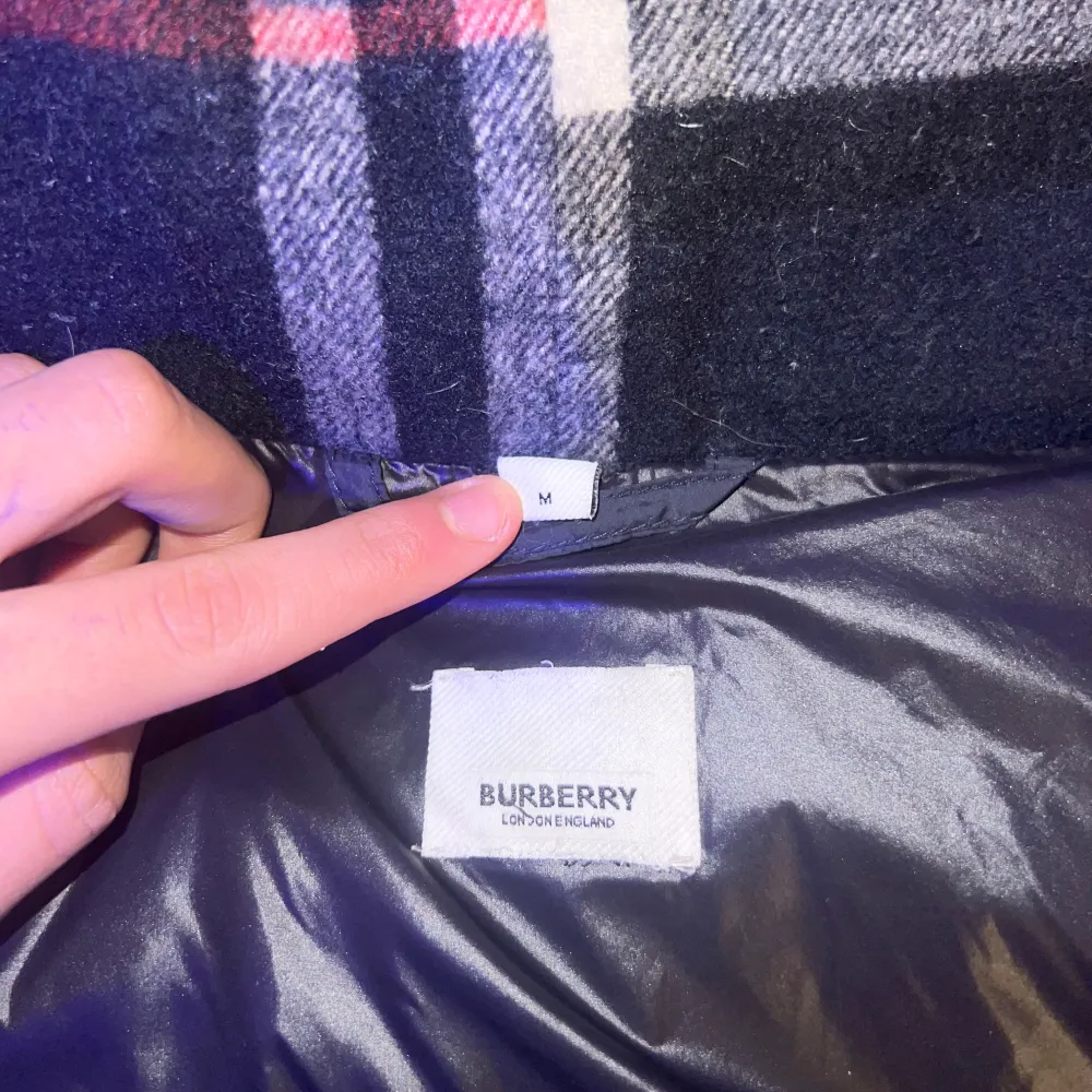 Säljer en stilren svart dunjacka från Burberry. Jackan har en klassisk rutig insida och är perfekt för kyliga dagar. Den har långa ärmar och en snygg design med Burberry-logga på ärmen. Passar perfekt för dig som vill ha både stil och komfort kan bli väst och funkar perfekt till sommaren skriv vid intresse eller om ni har frågor priset går att diskutera👍🏽. Takit.