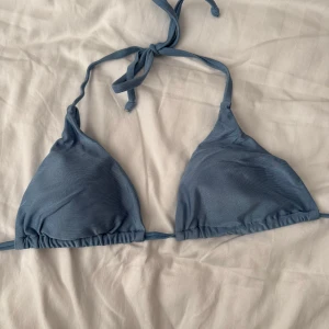 Blå bikiniöverdel - Snygg blå bikiniöverdel med knytband i nacken och ryggen. Perfekt för en dag på stranden eller vid poolen. Enkel och stilren design som passar till det mesta.