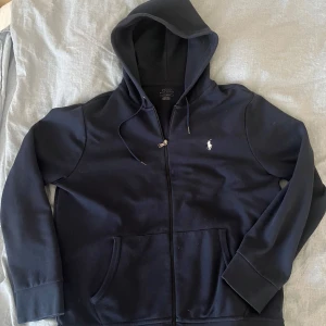 Mörkblå hoodie från Polo Ralph Lauren - Säljer denna tröja från Ralph lauren. Bra skick, liten defekt på snöret till luvan