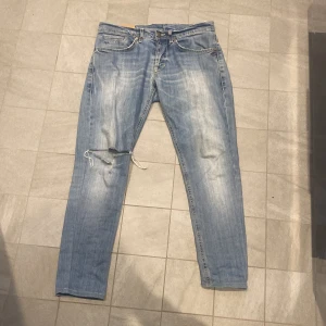 Dondup Jeans - Ett par Asfeta dondup jeans i storlek 33 som kan passa i princip alla, har 32/32 i jeans o dom sitter perfekt på mig! Passar slim, tror modellen är George. Stor slitning på högerknät som förra ägaren sydde ihop, går att ha kvar eller ta bort om man vill det! 8/10 skick inga defekter förutom knät som är design. Vid frågor eller funderingar skicka iväg ett meddelande!