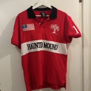 Haunted Mound official polo merch  - Officiell Haunted Mound polo merch i färgen röd, mycket bra skick 