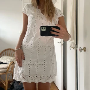 Vit klänning med spetsdetaljer - Så fin luftig vit klänning med spetsdetaljer och broderier, perfekt som studentklänning! På lappen står storlek XL men skulle säga att den är mer som en M (jag är 171 cm)💞
