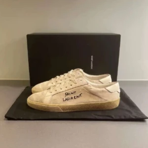  Saint Laurent skor  - Hej! Säljer nu dessa sjukt snygga Beigea Saint Laurent SL/06 skorna, Ok skick, finns defekter. Storlek 42,5 men passar 0,5-1 storlek större. Tillkommer Box, dustabg & kort. fler fragor? hör av dig🙌