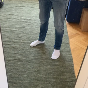 Replay Anbass - Snygga Replay Anbass med hål vid knäna. Trendiga Slim Fit jeans!