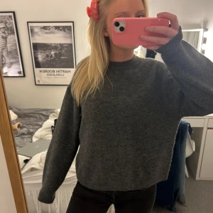 Grå stickad tröja från H&M - Säljer en mysig grå stickad tröja från H&M. Tröjan har en klassisk rund hals och långa ärmar, perfekt för kyligare dagar. Enkel och stilren design som passar till det mesta. Perfekt för höst och vinter!