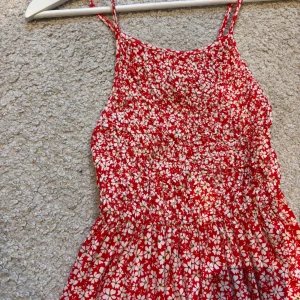 blommig klänning från Zara  - Säljer en söt röd klänning med vita blommor. Sälj då den inte ön används mer, den är inte heller använd my key och har därför ett väldigt bra skick. 