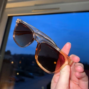 Transparenta solglasögon med brun ton - Snygga solglasögon med transparent båge och bruna linser. Perfekta för soliga dagar och ger en cool look. Kommer med ett svart fodral för säker förvaring. Knappt använda så är som nya